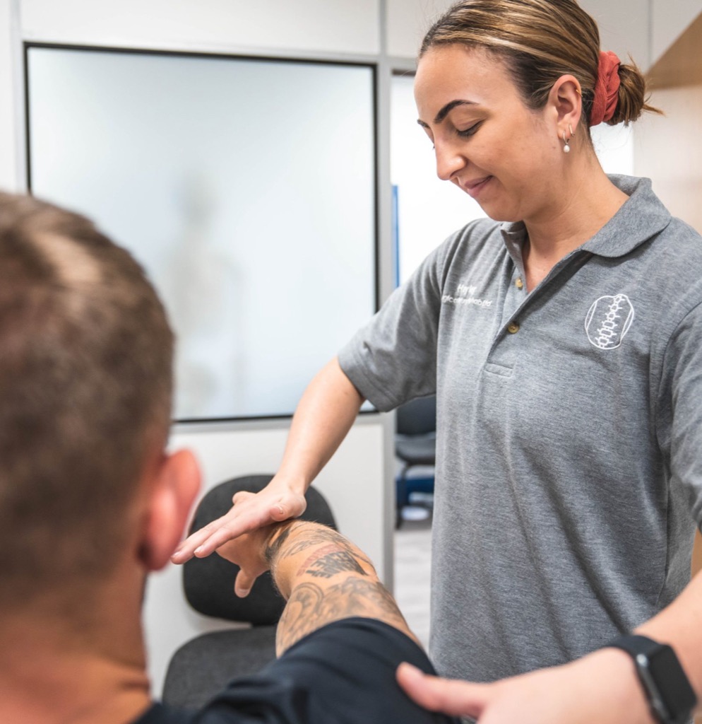 Injury rehab specialist treating a client's forearm at Logical Injury Rehab, Blackburn