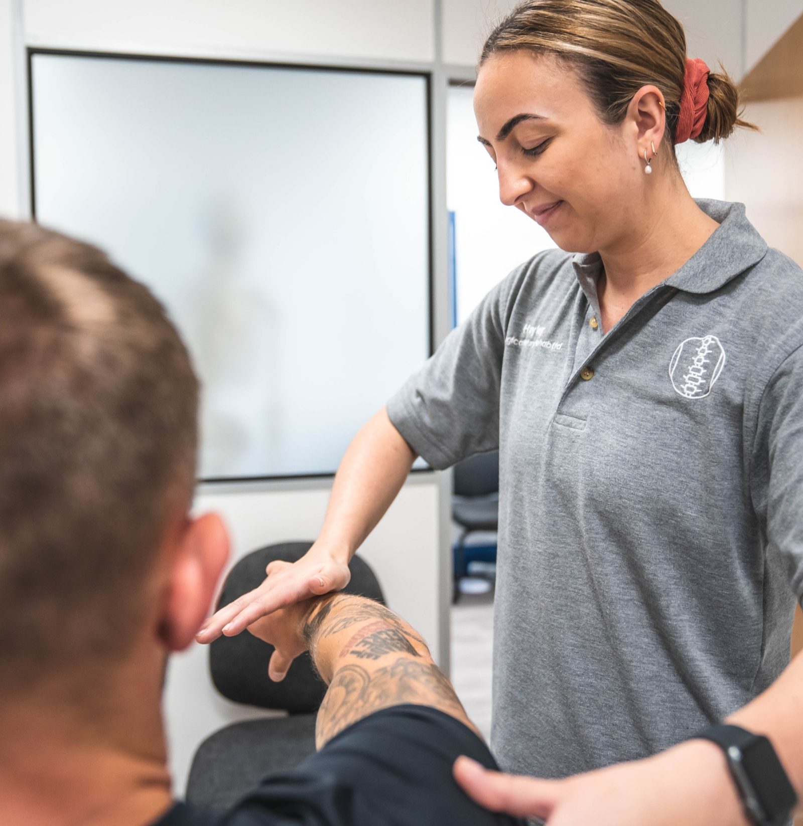 Injury rehab specialist treating a client's forearm at Logical Injury Rehab, Blackburn